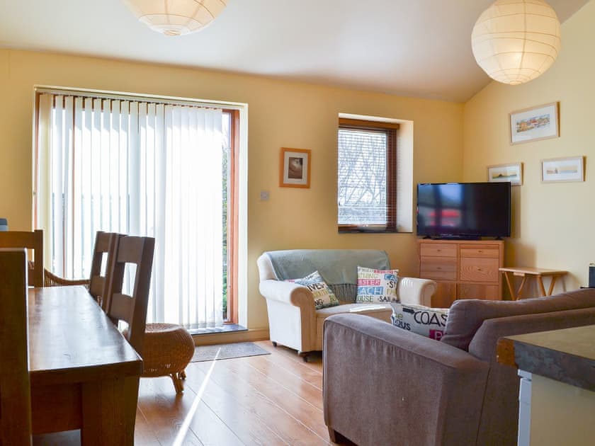 Spacious living area with dining table next to the patio doors | Tregella Farm Cottage, Near Padstow