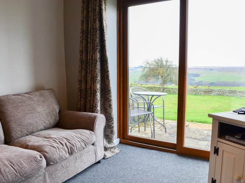 Comfortable living room with sliding doors to the patio | Granary Cottage - Common House Farm, Melkridge