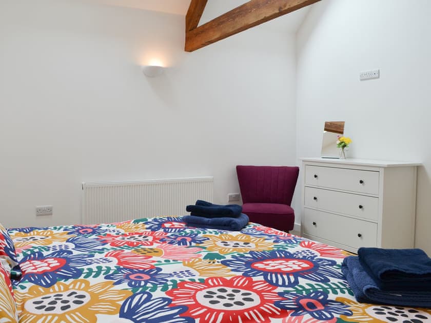 Bedroom with exposed ceiling trusses | The Wheel House, East Hill, near Ottery St Mary