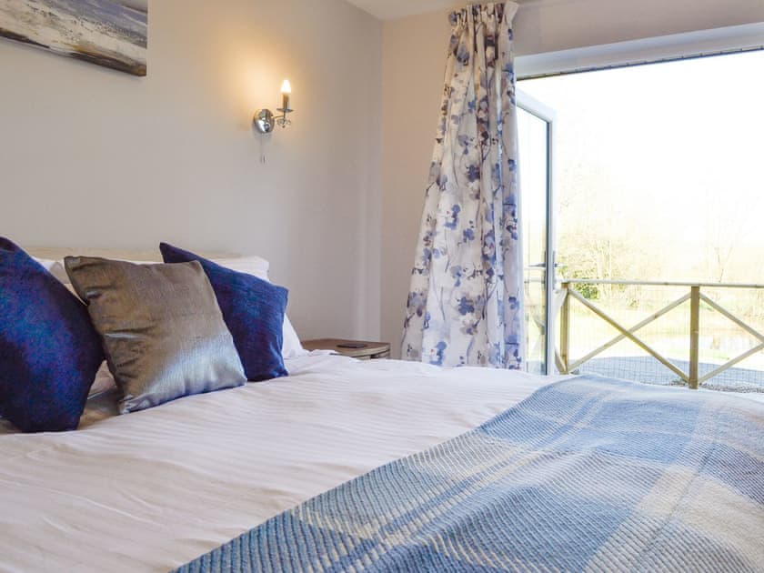 French doors to decked patio from double bedroom | Lakeside Lodge, near Rhayader