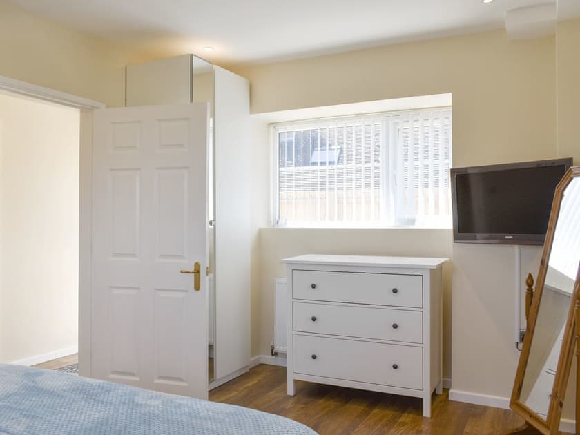 Ample storage and wall-mounted TV within double bedroom | Stars Cottage, Moreton, near Wareham