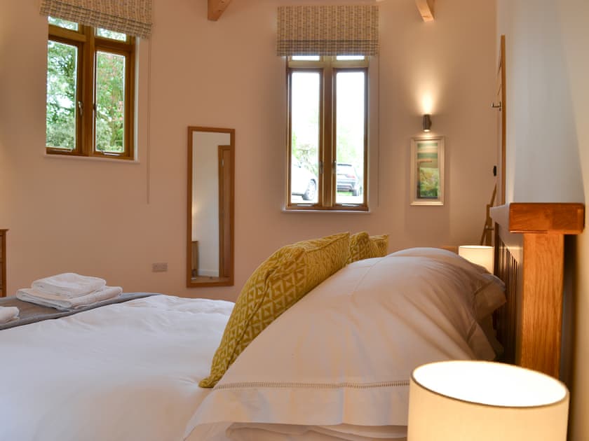 Semi-circular spacious ground floor kingsize bedroom  | The Horse Gin - Higher Blagrove Farm Cottages, East Worlington, near South Molton