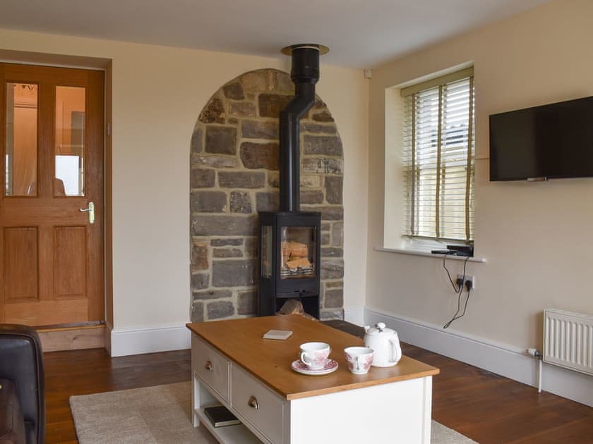 Living room/dining room featuring a stone fireplace and log burner | Woodside Cottage, Near Easington