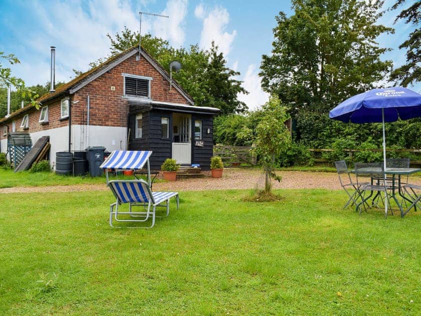 Lawned grounds with sitting-out area and furniture | Evie Rose Cottage, Elsenham, near Bishop’s Stortford 