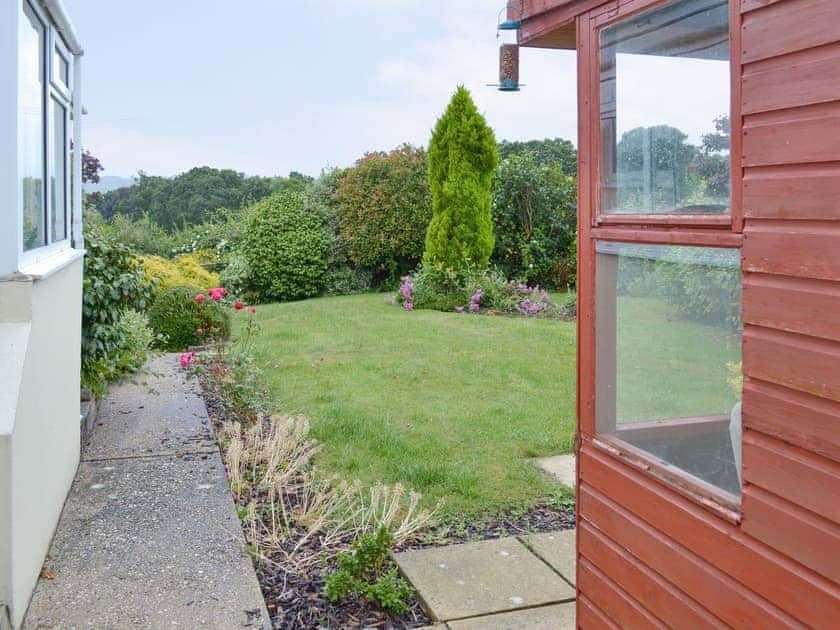 Lawned area front and rear. Rear garden is pet secure with summerhouse containing garden furniture -  sufficient room to store cycles. | Dart Corner, Bovey Tracey