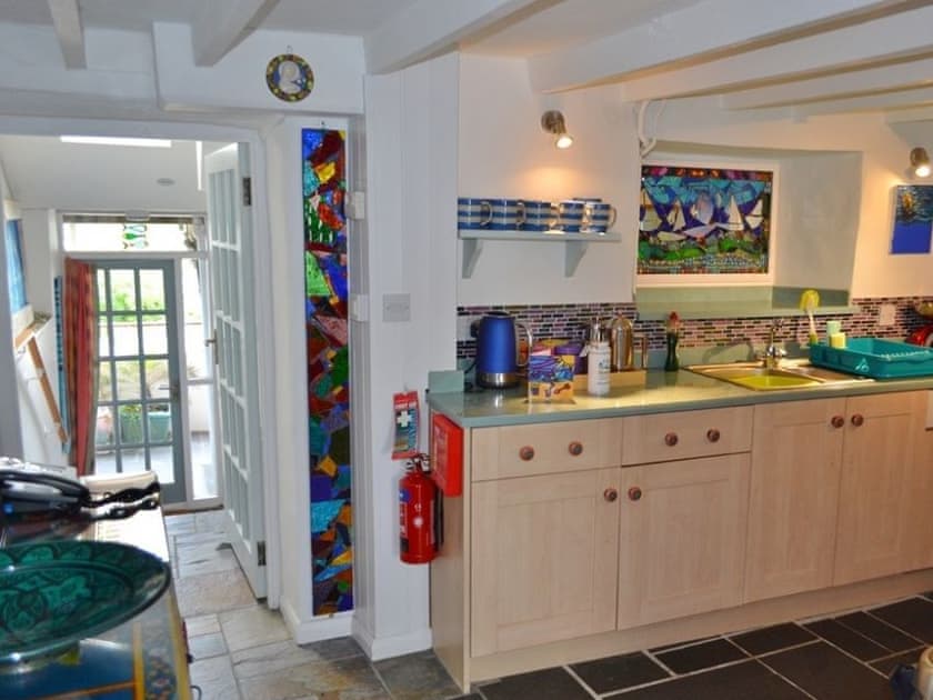 A particular feature of the ktichen is the glass mosaic panel and attractive hanging lamp | Polbathic, Fowey