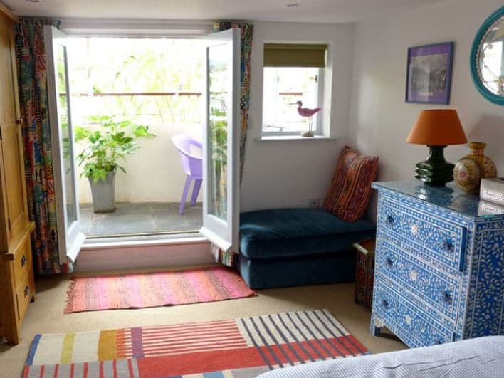 Patio doors lead out onto a private terrace from the master bedroom | Polbathic, Fowey