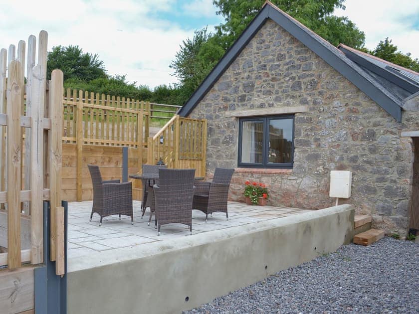 Raised paved patio with table and chairs | Scrumpy Barn - Hayes Farm Mews, Luton, near Newton Abbot