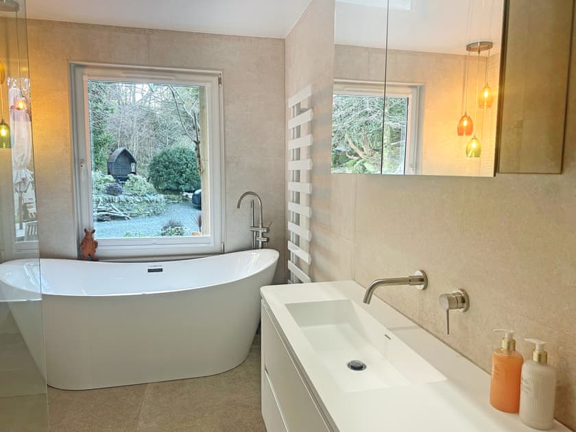 Master bathroom with luxury jacuzzi bath in a picture window with courtyard view and mood lighting | Tigh-na-Creige, Colintraive