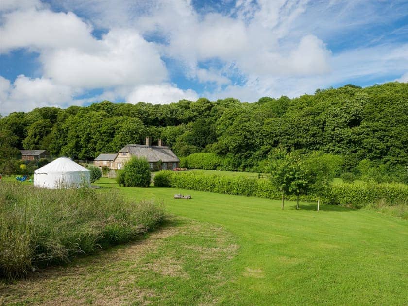 Play field with yurt and play equipment for children | Greenwood Grange Cottages, Higher Bockhampton, near Dorchester
