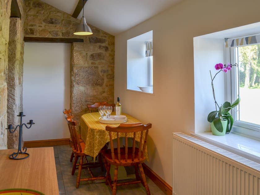 Dining area with exposed stone walls | Mains Cottage, Belford, near Bamburgh