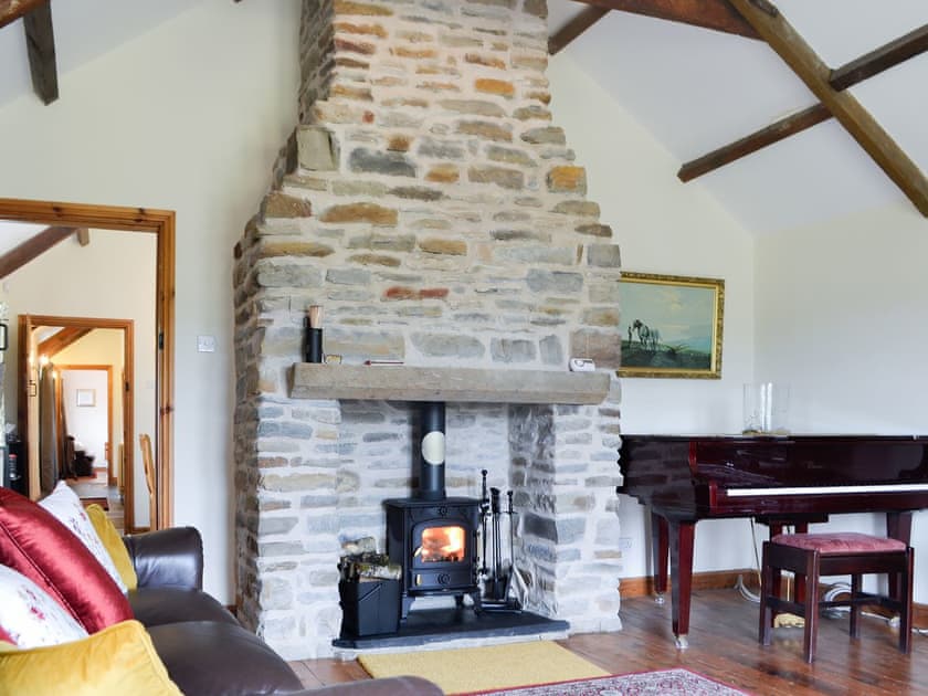 Impressive stone fireplace and piano in the living room | Ty Hir, Pontyates, near Kidwelly