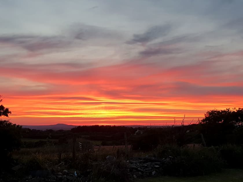Dramatic sunsets can be experienced from the garden | Penrhos Bach, Carmel, near Llangefni