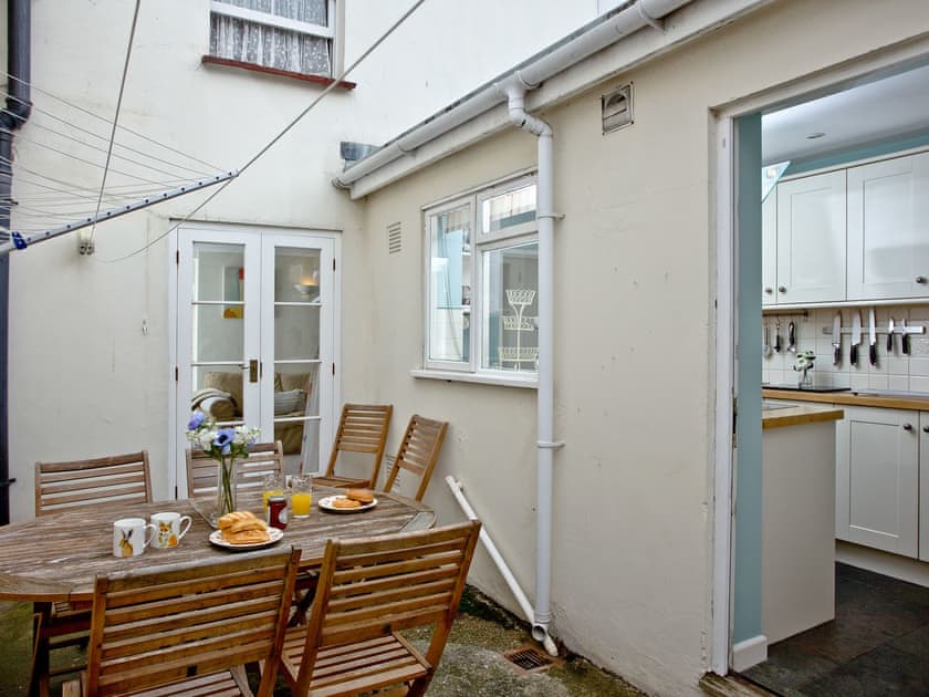 Courtyard area with dining table and chairs | Whitestones, Weymouth