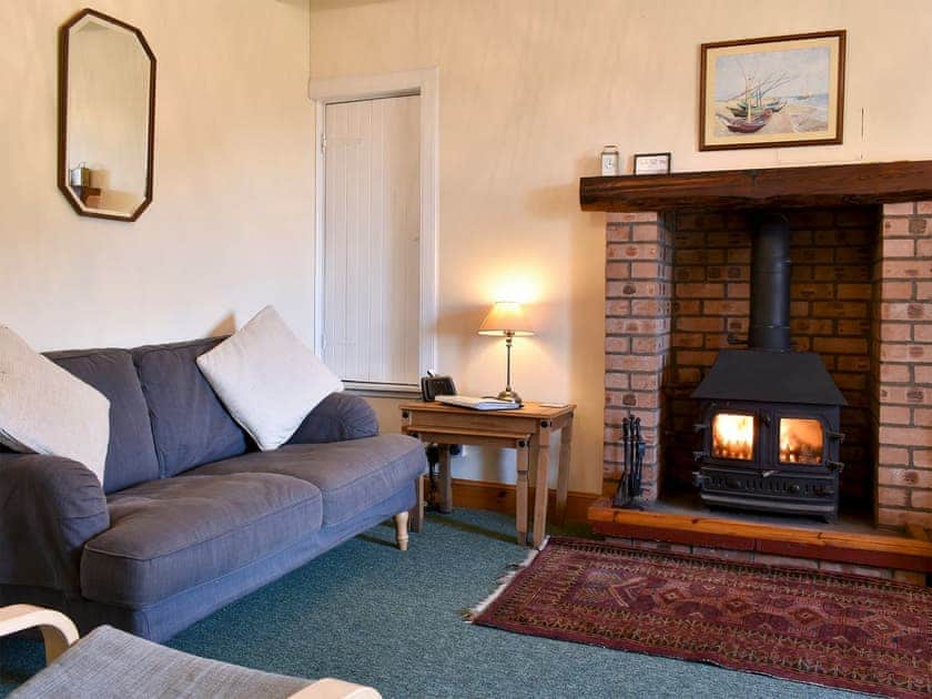 Comfortable living/dining room with wood burner | Burnside Cottage, Sliddery, Isle of Arran