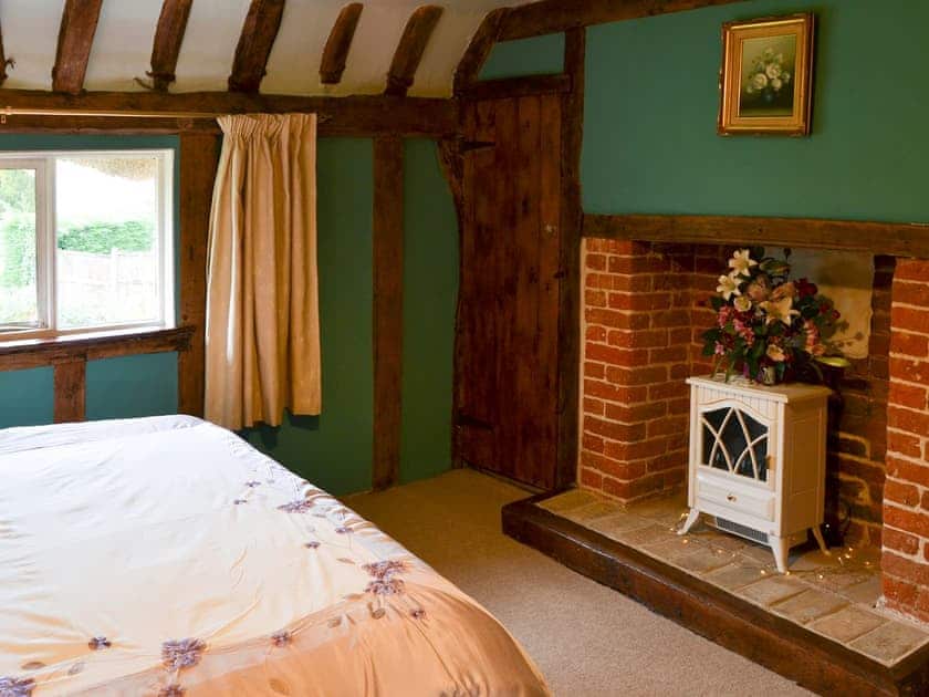 Double bedded room with feature fireplace | Tattlepot Farmhouse, Pulham Market, near Diss