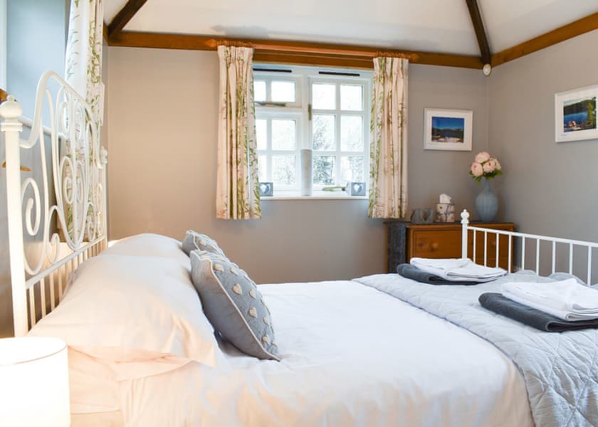 Comfortable bedroom with antique style bed | Yew Tree Cottage, Farnham, near Blandford Forum