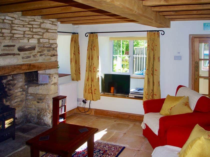 Charming living room with exposed stone fireplace | Ivy Cottage, Chedworth, near Cheltenham