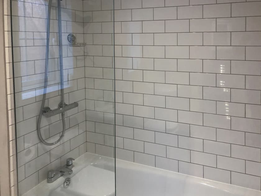 Tiled bathroom with shower over the bath | Seascape, Beadnell