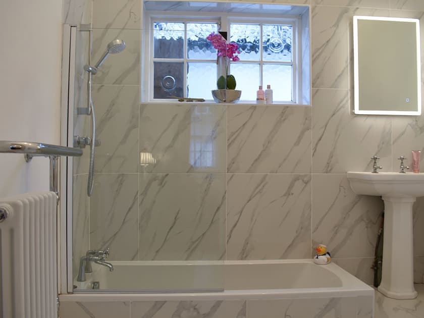 En-suite with shower over the bath | The Cottage by the Sea - The Cottages by the Sea, Littlehampton, near Arundel