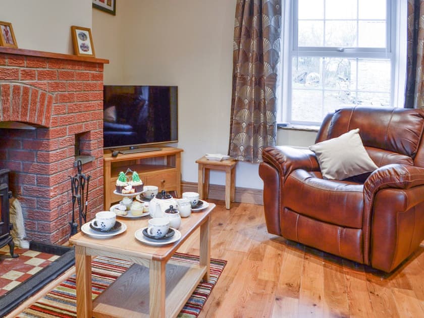 Relaxing living room with open fireplaced home to a cheerful woodburner | Felin Gogoyan - Cambrian Mountains Glamping, Tregaron, near Lampeter