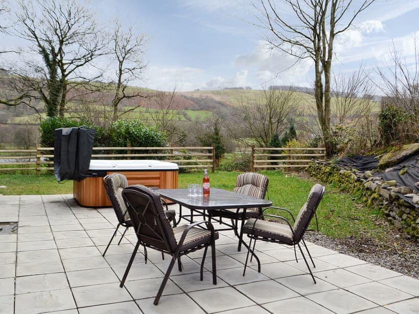 Paved patio with hot tub and outdoor furniture | Felin Gogoyan - Cambrian Mountains Glamping, Tregaron, near Lampeter