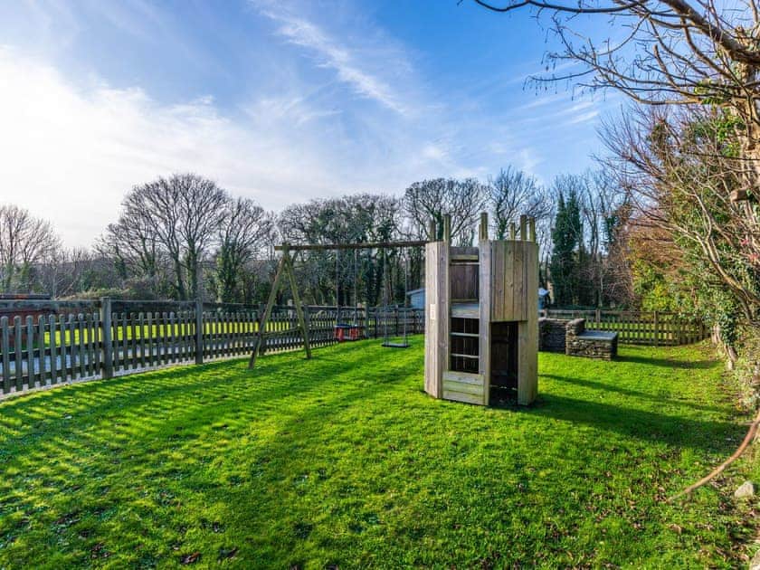 Lawned area with children’s play equipment | Dairy Cottage, Fowey