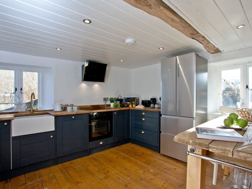 Fully equipped kitchen with dining area within the open-plan design | The Old Mill, Egloskerry, near Launceston