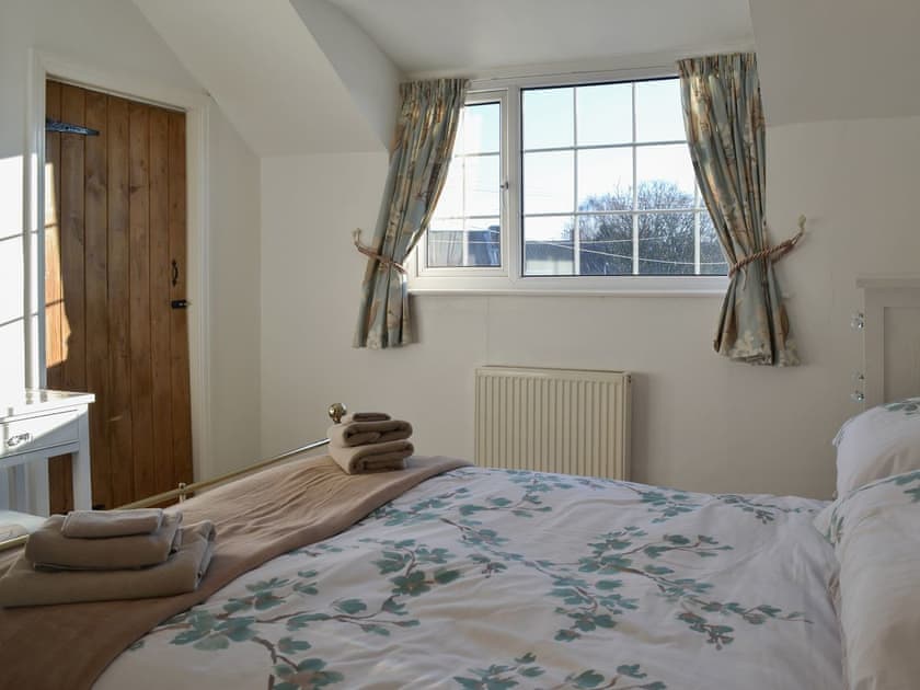 Pretty bedroom with antique-style bed | Squirrel Cottage, Seamer, near Scarborough