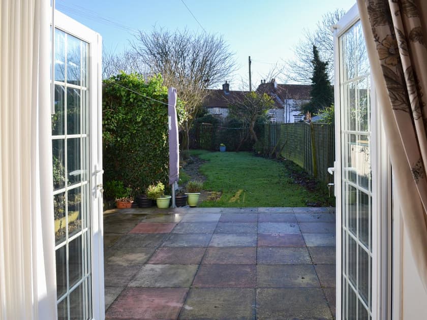 Paved patio from the double doors in the living room | Squirrel Cottage, Seamer, near Scarborough