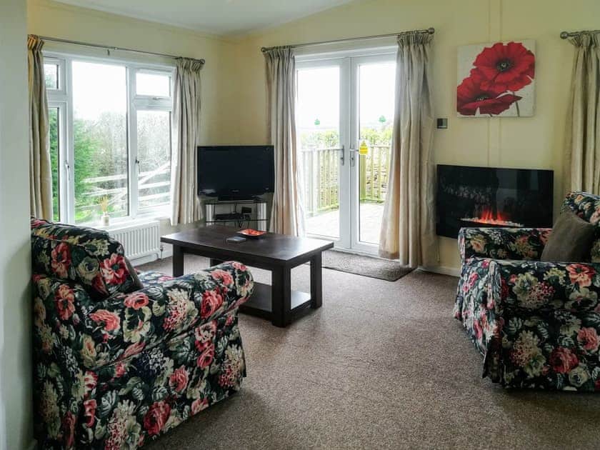 Welcoming living area with French doors to decked terrace | Apple Blossom - Yonder Green Lodges, St Ervan, near Padstow