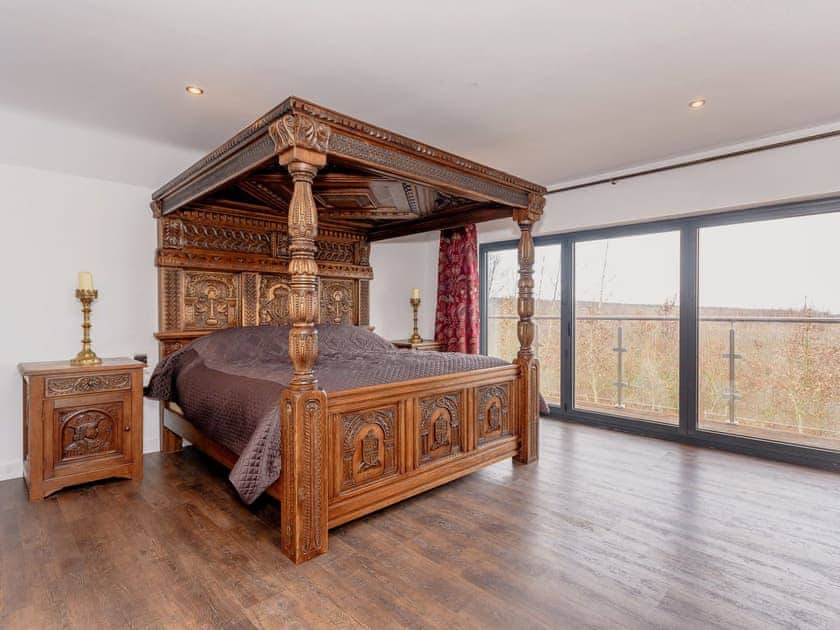 Relaxing en-suite four poster bedroom with balcony access | Olive Lodge, Melbourne, near Derby