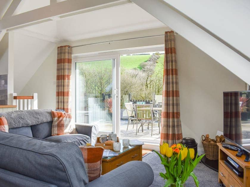 Living area with patio doors to roof terrace  | Camellia Cottage - Kilbol Country Cottages, Polmassick, near St Austell