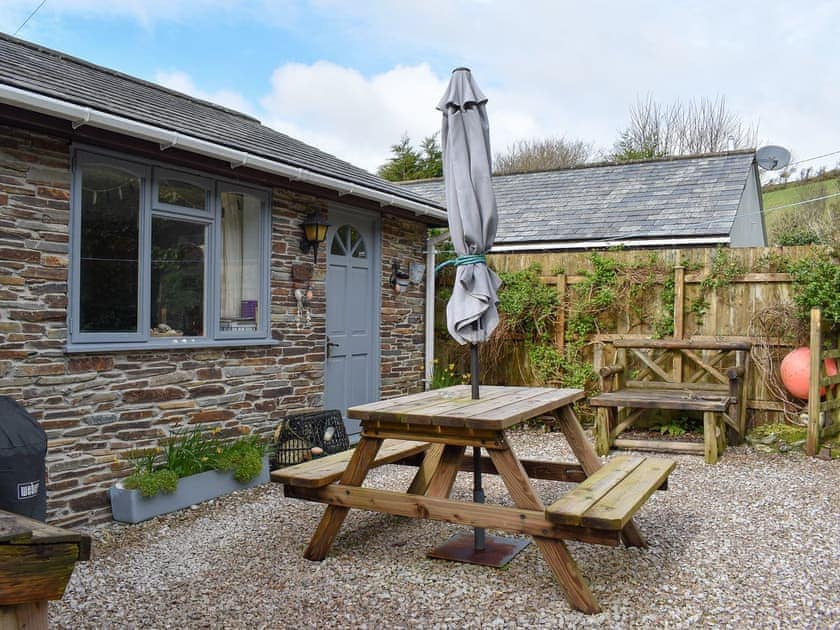 Exterior with seating area | Garden Cottage - Talland Beach Cottages, Talland Bay, near West Looe