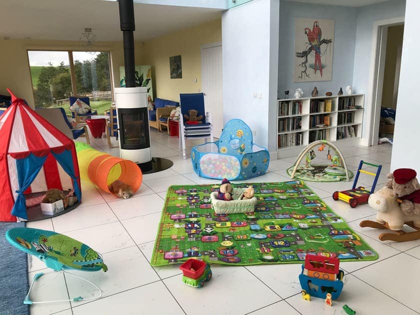 Blue chairs can be stacked in order to turn atrium into a playroom (young children) | Wester Auchleuchrie, Memus, near Kirriemuir
