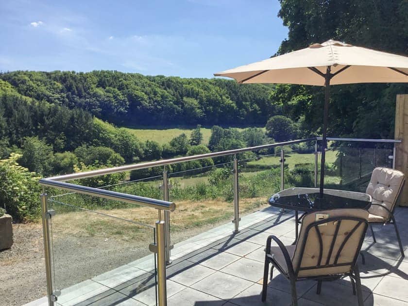 Patio with table and chairs overlooking the beautiful Cornish landscape | Orchard Close - Sanctuary Farm Cottages, Morwenstow, near Bude