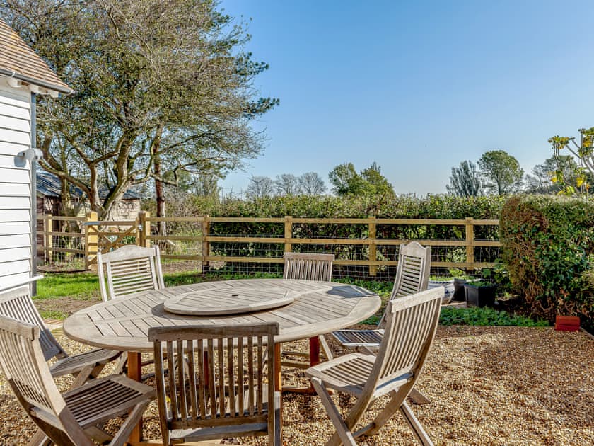 Sitting-out-area. A sunny sheltered dining/seating area with views over the fields | Mark Farmhouse, Tillingham, near Southminster