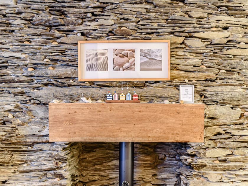 Characterful feature wall in the living area | Pebble Cottage - Aberlovely Holidays, Aberdovey