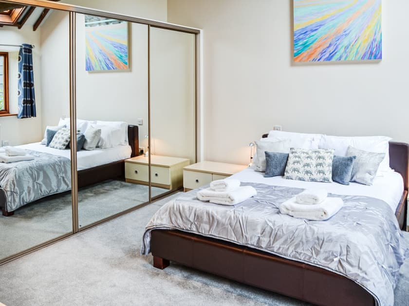 King master bedroom. Complete with full ensuite, double sinks Jacuzzi bath shower and heated towel rail with French doors to the courtyard | Lodge Farm Barn, South Walsham