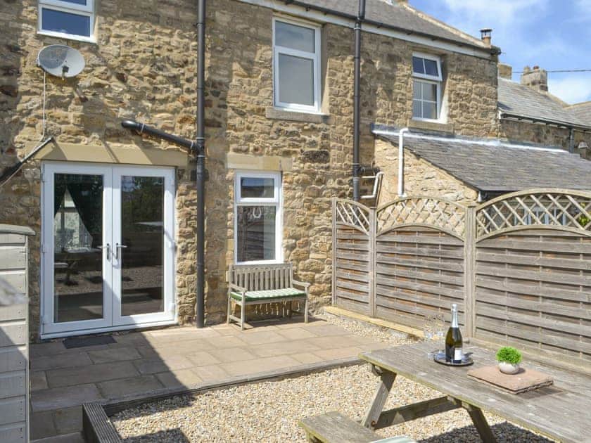 Patio to the rear of the holiday home | Dolly’s Cottage, Ovington