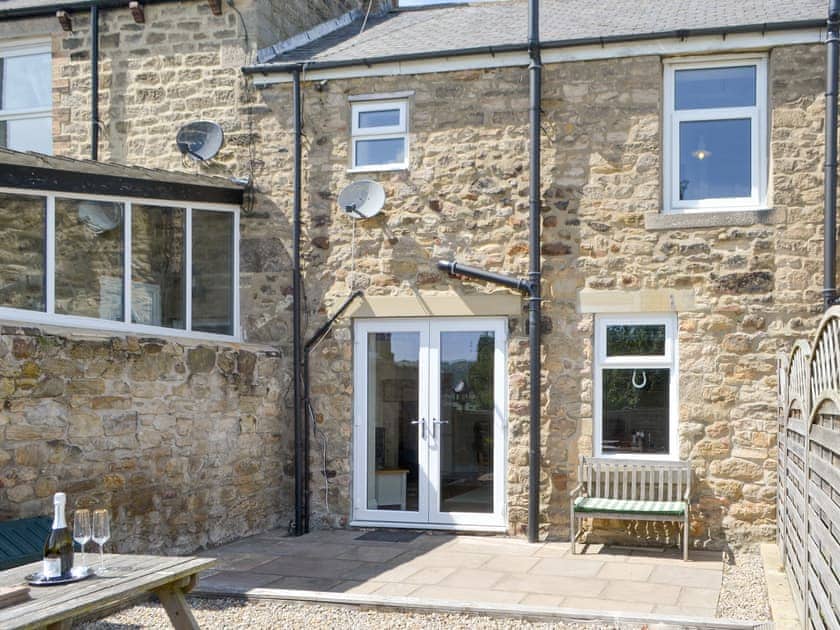 Patio to the rear of the holiday home | Dolly’s Cottage, Ovington
