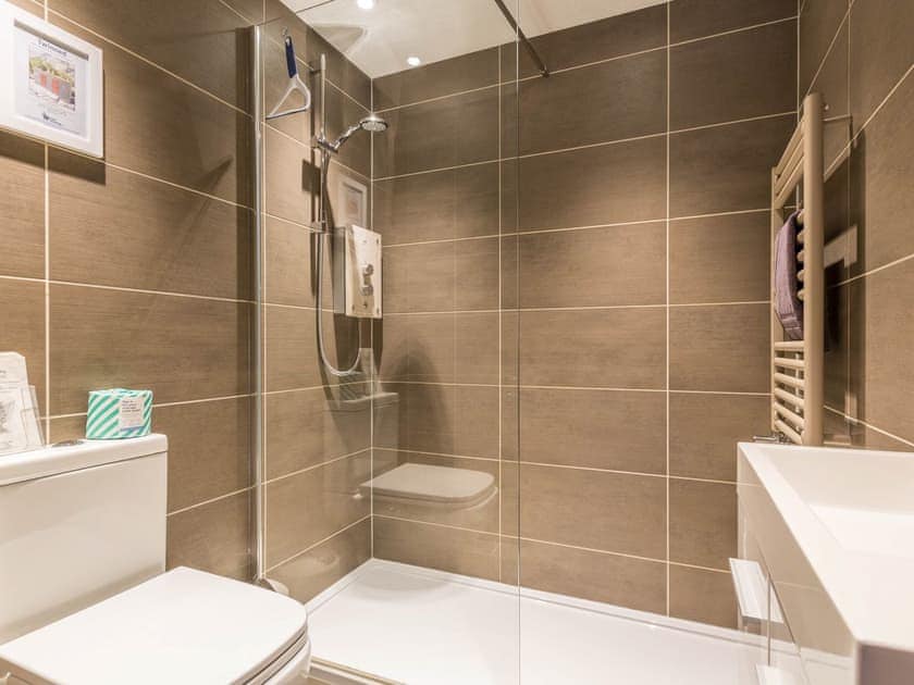 En suite shower room with floor to celing tiles | April Cottage, Windermere