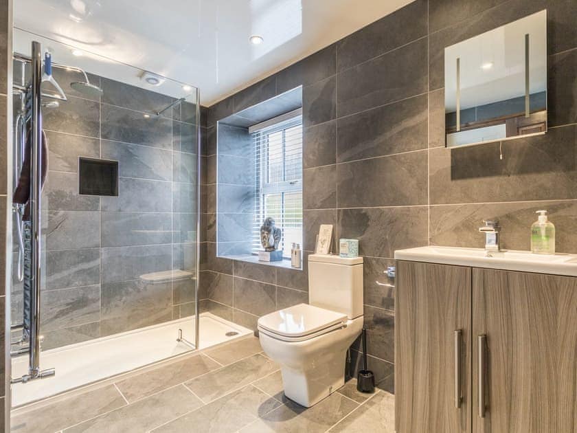 Shower room with walk-in shower, floor to ceiling tiles and heated towel rail | April Cottage, Windermere