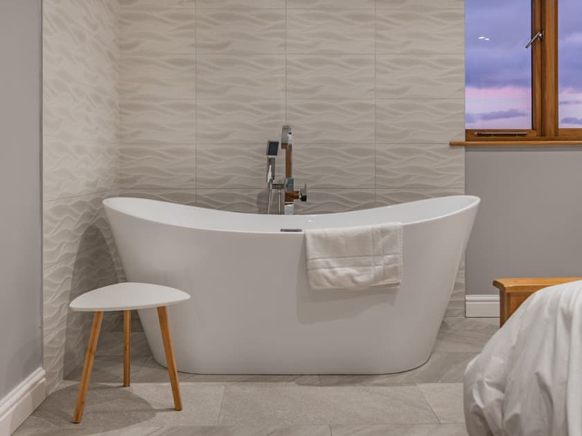 Free standing bath within double bedroom | Ty Cwtch - Anglesey Seaviews, Penrhos Feilw, near Trearddur Bay