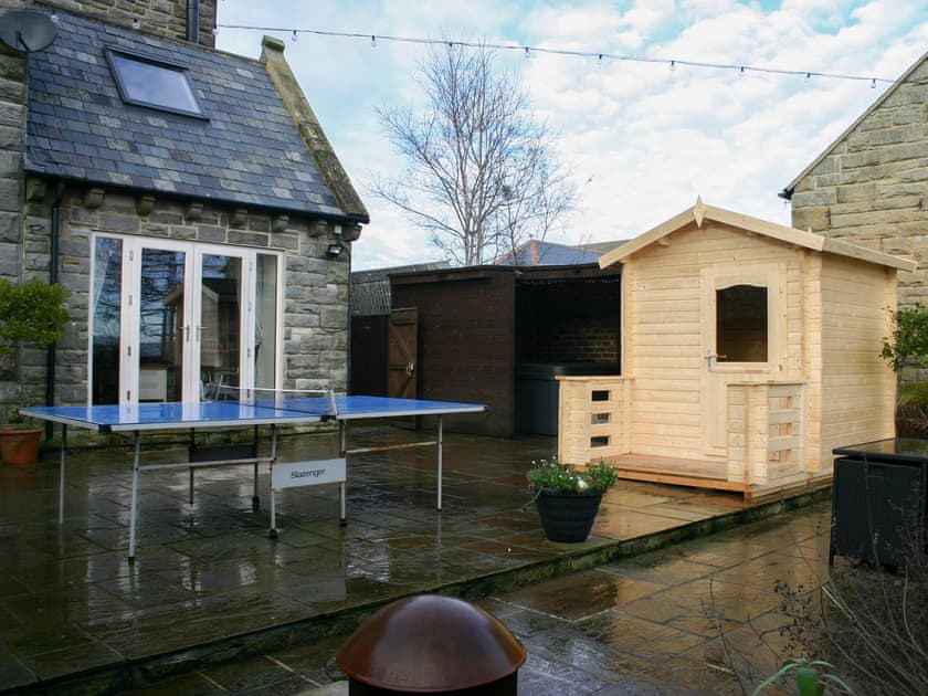 The back garden with table tennis, the sauna and the hot tub enclosure in the background | Woodside Cottage, Near Easington