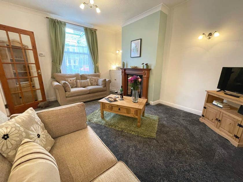 Comfortable living room with an open fireplace | Lavender Cottage, Keswick