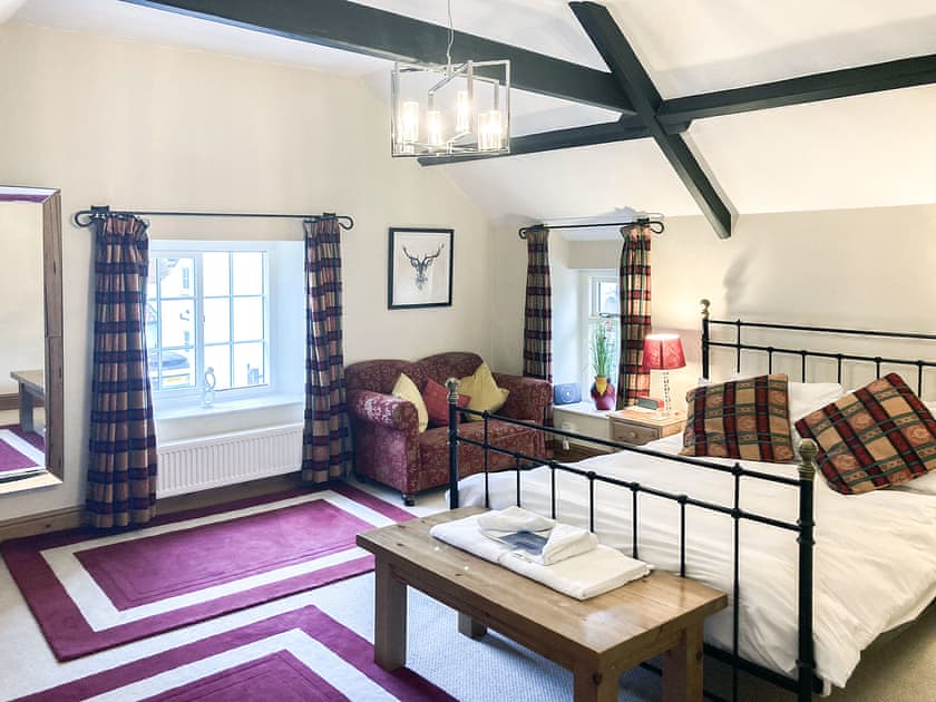 Period and inviting beamed master bedroom with kingsize bed  | Forge View Cottage, Thornton-le-Dale, near Pickering