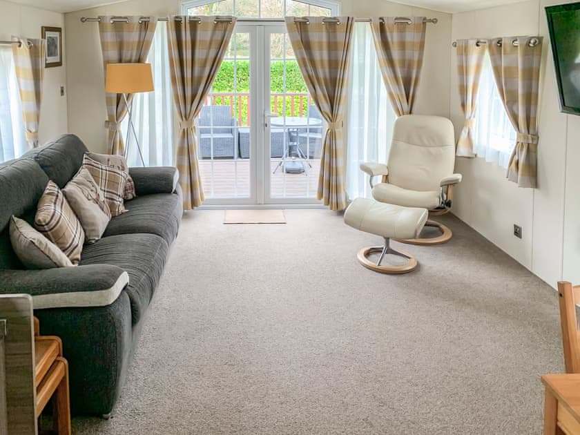 Living area with French doors to the decked terrace | Bridge End Lodge, Dollar, near Stirling