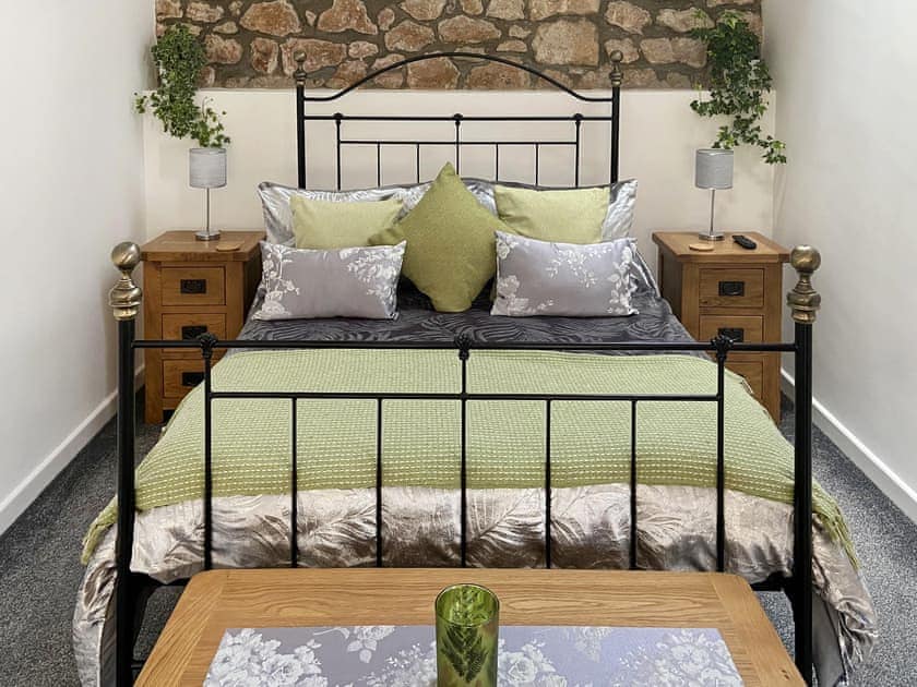 Double bedroom with feature stone walls | The Old Dairy Annexe, Donyatt