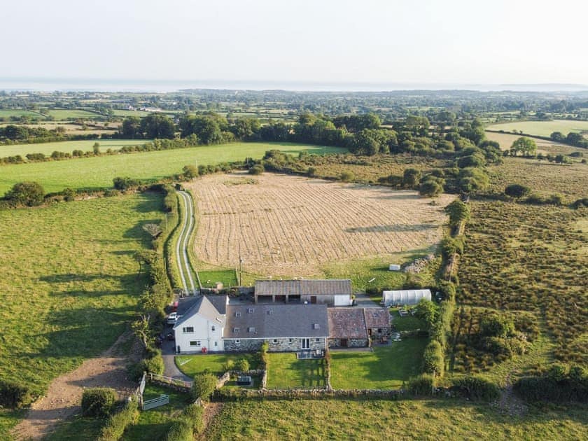 Rear aerial view of cottages at Tyn Lon Isaf and Cardigan Bay | Beudy Canol - Tyn Lon Isaf, Llangybi, near Pwllheli